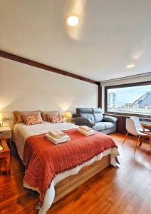 1 dormitorio con 1 cama grande y 1 sofá en Desconectaengalicia Estudio Puerta del Sol en Vigo