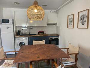 a kitchen with a wooden table and a dining room at Ático con encanto en Cerdanya in Martinet