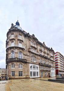 a large stone building with white windows on a street at Centro Vigo Estudio Puerta del Sol in Vigo