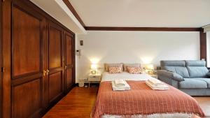 een slaapkamer met een bed en een bank bij Desconectaengalicia Estudio Puerta del Sol in Vigo