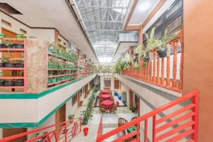 a corridor of a building with tables and plants at RedDoorz Syariah near Alun Alun Sumedang in Sumedang