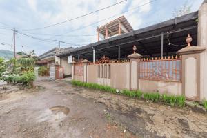 a house with a fence in front of it at RedDoorz Syariah near Alun Alun Sumedang in Sumedang