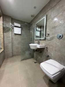 a bathroom with a toilet and a sink and a shower at Hotel Vedas Heritage in New Delhi