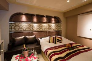 a bedroom with a large bed with a wooden headboard at ホテルコスタリゾート飯能 in Hannō