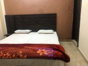 ein Schlafzimmer mit einem Bett mit einer roten Decke darauf in der Unterkunft Blessings Lounge in Saharanpur
