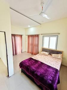 a bedroom with a bed with a purple blanket at CityAir in Pune