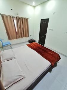sypialnia z dużym łóżkiem i czerwonym kocem w obiekcie CityAir w mieście Pune