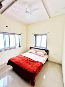 a bed in a room with two windows at CityAir in Pune