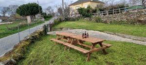 a wooden picnic table sitting on the grass at Casa da Baltasara in Trives