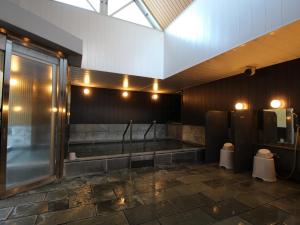 a bathroom with a tub and a toilet and lights at APA Hotel Toyama Ekimae in Toyama +82 photos