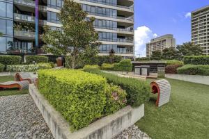 a park with benches and bushes in front of a building at Nice in New Acton - 2bd 2bth Apt in Canberra