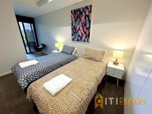 two beds sitting next to each other in a room at Nice in New Acton - 2bd 2bth Apt in Canberra