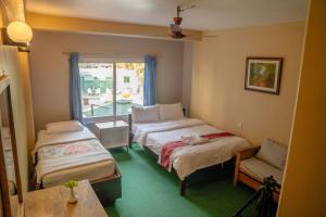a room with two beds and a window at Nepali Cottage Guest House in Pokhara