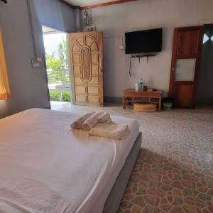 1 dormitorio con 1 cama con 2 toallas en Lanta msd bungalow en Phra Ae beach
