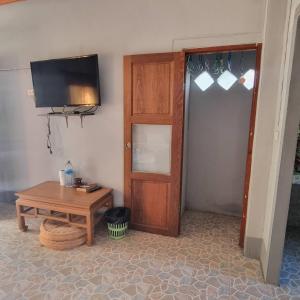 Habitación con puerta, mesa y TV en Lanta msd bungalow en Phra Ae beach