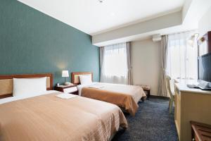 广岛Hiroshima Intelligent Hotel Annex的有两张床和一台电视的酒店房间