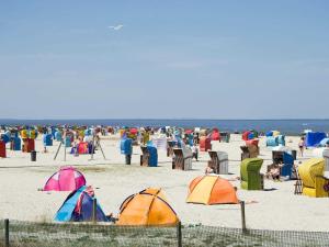 un grupo de personas en una playa con tiendas de campaña en Ferienhaus Deichstraße 10d, en Carolinensiel