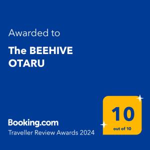 a yellow sign with the text awarded to the beehive otaru at The BEEHIVE OTARU in Otaru