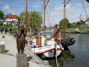 a statue of a person taking a picture of a boat at Ferienhaus Schulte in Carolinensiel