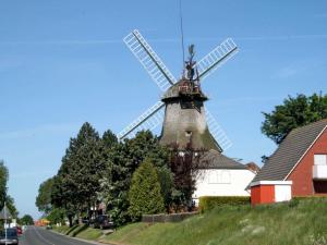a windmill sitting on the side of a road at Ferienhaus Schulte in Carolinensiel