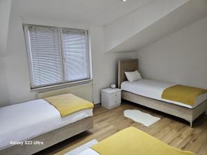 twee bedden in een kamer met twee ramen bij Apartment City View in Bihać