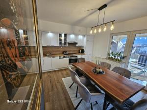 een grote keuken met een houten tafel en stoelen bij Apartment City View in Bihać +16 foto's