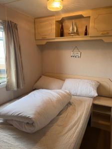 a bedroom with two beds in a small room at AMS Caravan Holidays in Ingoldmells