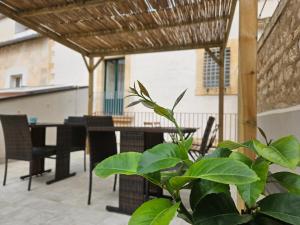 un patio con mesa, sillas y una planta en B&B Mormina, en Scicli