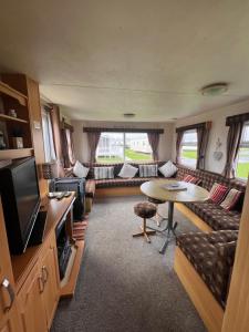 a living room with a couch and a table at AMS Caravan Holidays in Ingoldmells