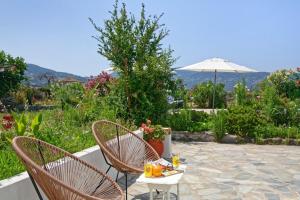 a patio with two chairs and an umbrella at Τhalassa Home Fine Living in Petra