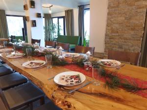 una larga mesa de madera con platos de comida. en Karadzhovata Kashta en Zlatograd