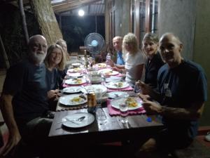 un grupo de personas sentadas alrededor de una mesa comiendo comida en Wilpattu Mookalan Resort en Habawewa