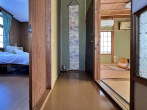 a room with a bedroom with a bed and a door at Guest House Korasshai Nakajo in Tokamachi