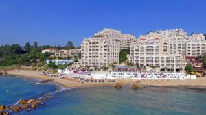 een uitzicht op een hotel en een strand met gebouwen bij La Mer Welcome in Goudstrand