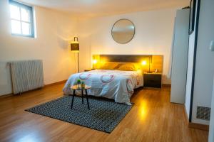 1 dormitorio con cama y espejo redondo en 100 m2 de charme vue sur la Loire, en Saint-Clément-des-Levées