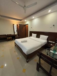 a bedroom with a large bed and a glass table at Tipsyy Inn & Suites Jaipur in Jaipur