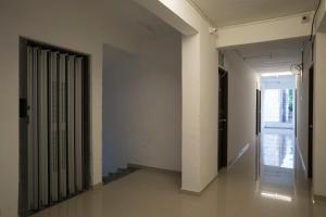 un couloir vide avec des murs blancs et un radiateur dans l'établissement RVC Hospitality Near Pune Airport, à Kharadi