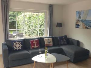 Una sala de estar con un sofá azul y una mesa. en Haus "Uferstraße 6n", en Carolinensiel