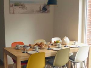 una mesa de comedor con sillas y un bol de fruta en Haus "Uferstraße 6n", en Carolinensiel 13 fotos más