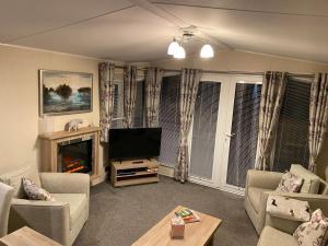 a living room with a television and a fireplace at No. 40 Golf View in Jedburgh