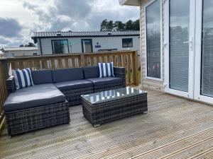 a patio with a couch and a table on a deck at No. 40 Golf View in Jedburgh