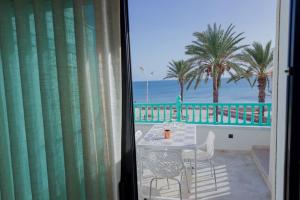 balcone con tavolo, sedie e vista sulla spiaggia. di Maison SOUAD a Mahdia