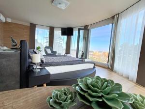 Un dormitorio con una cama y una mesa con una planta en WEST Panorama Penthouse - apartment with a fantastic view of the city, en Szombathely