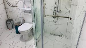a bathroom with a toilet and a glass shower at Guest house Roza in Kazarman +32 photos