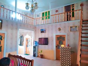 a living room with pink walls and a staircase at Fayz Hotel in Bukhara