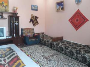 a living room with a couch and a chair at Fayz Hotel in Bukhara