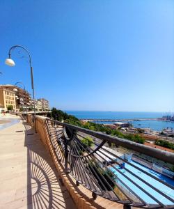 a bench on a balcony looking out at the ocean at Le Rose Apartment in Ortona