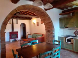 a kitchen and dining room with a table and a living room at Agriturismo Alle Rose in Volterra