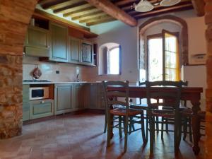 a kitchen with green cabinets and a table and chairs at Agriturismo Alle Rose in Volterra