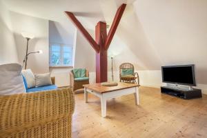 - un salon avec un canapé et une télévision dans l'établissement Wohnung Kemenate, à Trendelburg